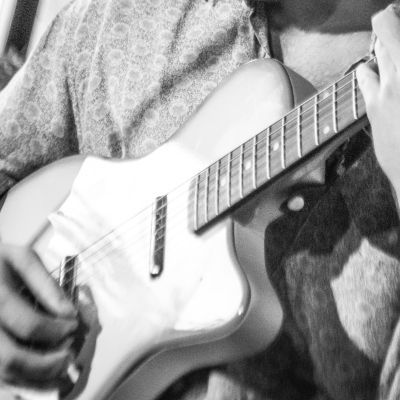 Black and white photo of person playing electric guitar